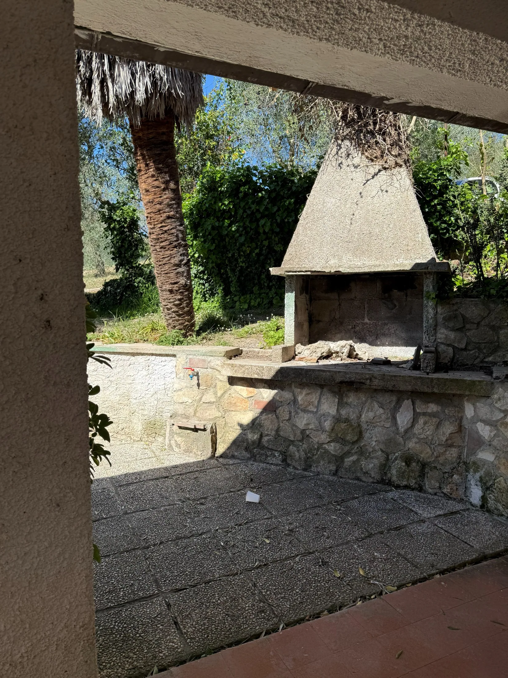 Veranda ombreggiata con camino esterno in pietra